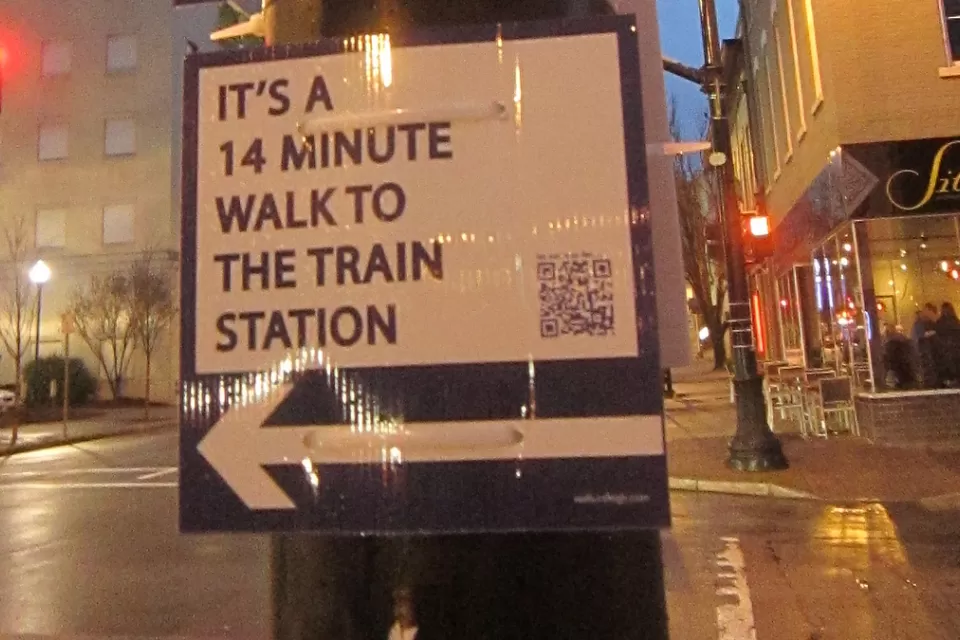 street sign in Raleigh showing length of walk to train station